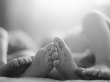 Low section of baby on bed at home