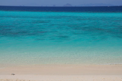 Scenic view of beach against blue sky