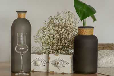 Close-up of flower vase on table against wall