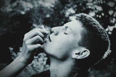 Close-up of man smoking with eyes closed