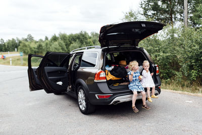 Girls sitting in open boot