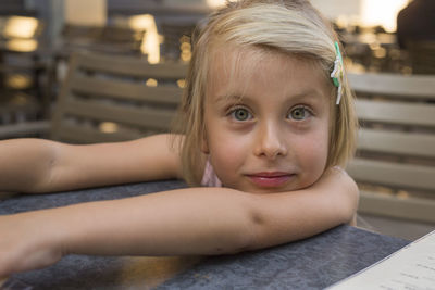 Portrait of cute girl sitting on table