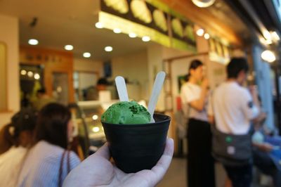 Person holding fresh ice cream cup at store