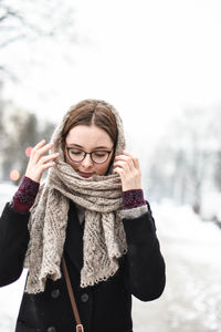 Woman wearing hat standing against snow during winter