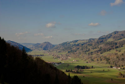 Scenic view of field and mountains against sky