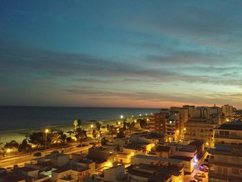 High angle view of townscape by sea against sky