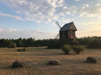 Traditional windmill on field against sky