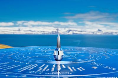 Close-up of navigational equipment against sea and blue sky