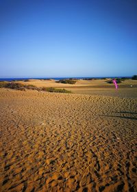 Scenic view of desert against clear blue sky