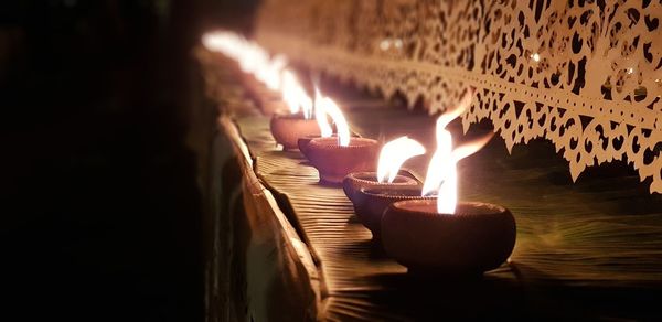 Close-up of burning diya on table