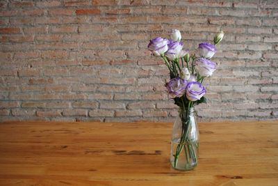 Close-up of flower vase against brick wall