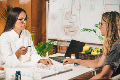 Dietician explaining nutritional facts label to client at weight loss clinic