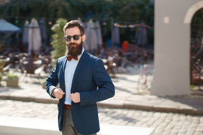 Portrait of young man standing in city