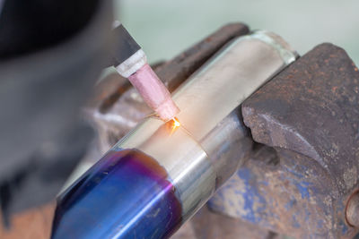 Close-up of person working on metal in workshop