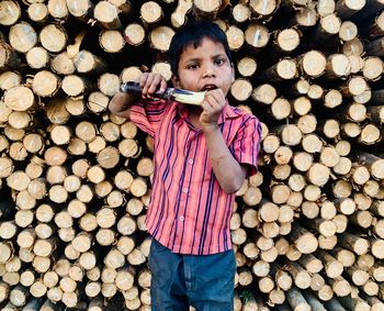 Full length portrait of boy standing on log