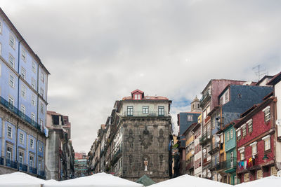 Buildings against cloudy sky