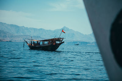 Boat sailing in sea against sky