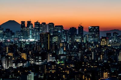 Illuminated cityscape against sky at night