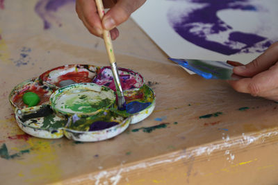 Close-up of hand holding a brush at table