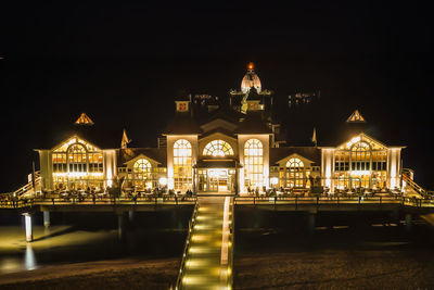 Illuminated building against clear sky at night