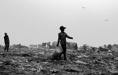 People standing on field against clear sky