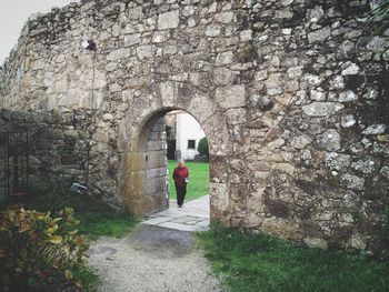 Woman standing by archway