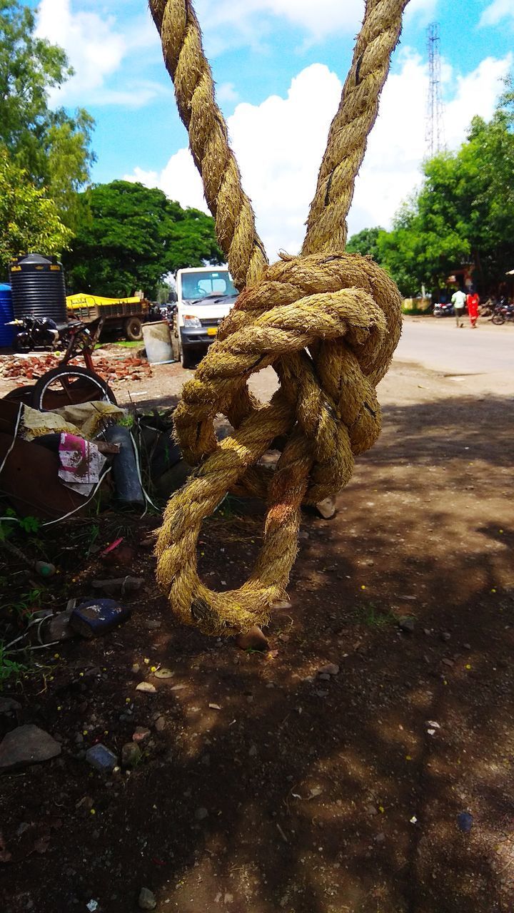 CLOSE-UP OF ROPE TIED UP OF METAL CHAIN