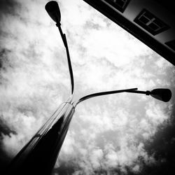 Low angle view of street light against cloudy sky