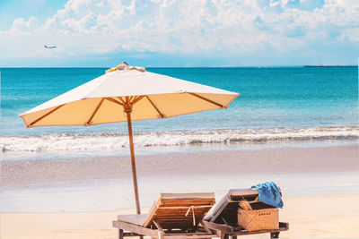 Sea landscape, romantic paradise, holidays background - two beach lounge chairs under tent on beach.