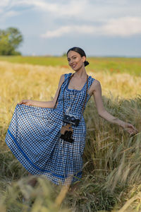 Portrait of young woman standing on field
