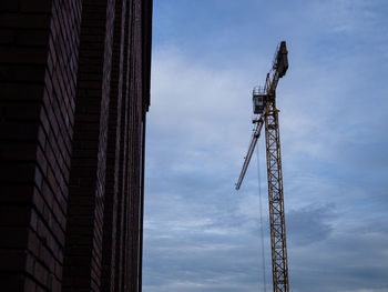 Low angle view of crane against building