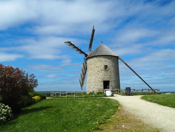 Traditional windmill on landscape against sky