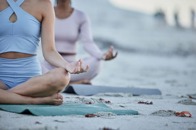 Low section of woman exercising at beach