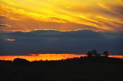 Scenic view of silhouette mountains against orange sky