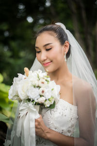Bride looking down while holding flower bouquet