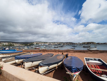 Boats moored on beach against sky