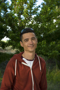 Portrait of smiling man standing against trees