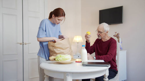 Nurse looking into grocery bag in nursing home