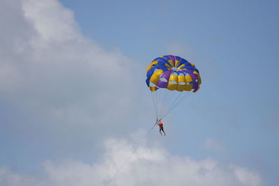 Low angle view of person skydiving with parachute against sky