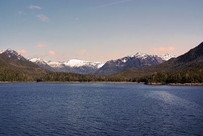 Scenic view of lake by snowcapped mountains against sky