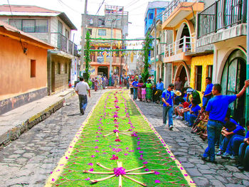 People on street amidst buildings in city