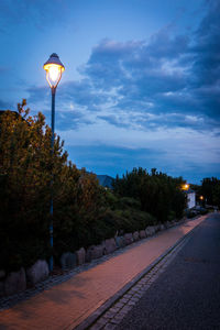 Street light by road against sky at dusk