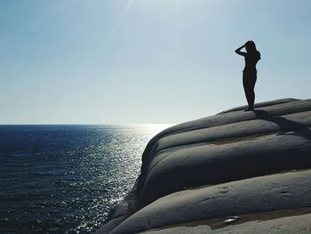 Silhouette of woman standing on rock