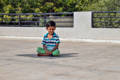 Full length portrait of boy sitting outdoors