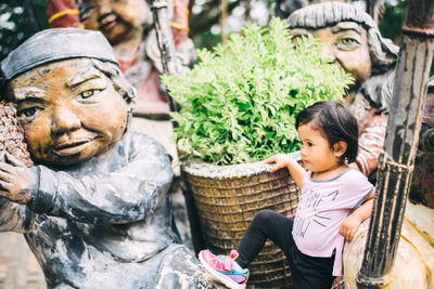 Girl standing by sculptures at market