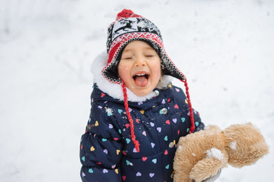 Child outdoors playing in snow. snowy winter weather.