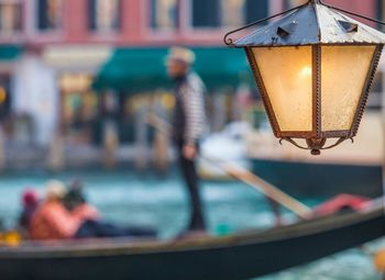 Close-up of illuminated lamp in canal in venice 