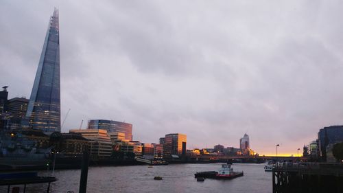 Boats sailing in river with city in background