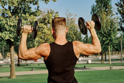 Midsection of man with arms raised