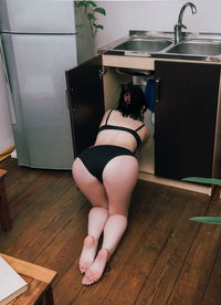 Rear view of woman in lingerie working at home